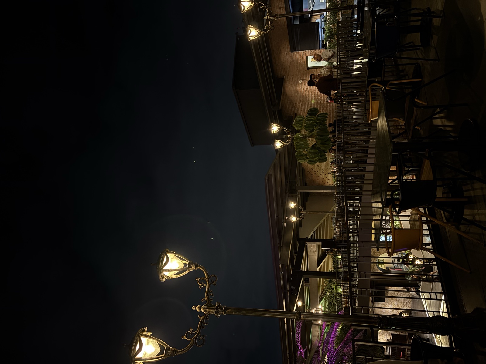 Ornate vintage street lamps lighting an open-air terrace after closing